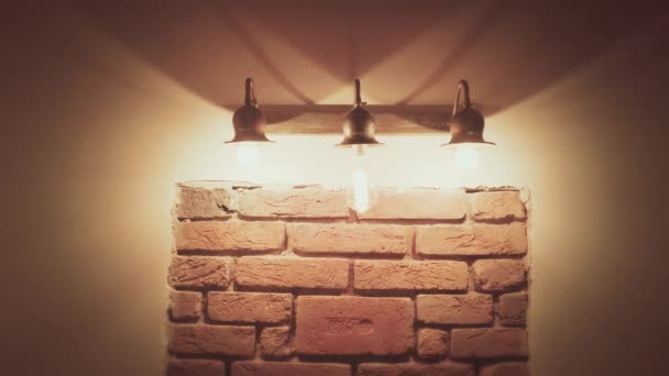 Stěna s dekorativními starými cihlami, osvětlená lampami, pohyb fotoaparátu, domácí dekorace — Stock video