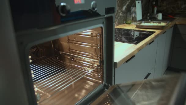 Homem abre e coloca pizza no forno para cozinhar, rastreamento de câmera — Vídeo de Stock