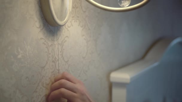 Mans hand, zet het licht van de lamp op de muur in de slaapkamer — Stockvideo