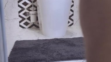 Şortunu çıkardıktan sonra tuvalete gelip tuvalette oturan bir adamın bacakları.