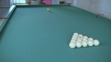 Bilardo oynayan, top piramidini kıran bir adam.