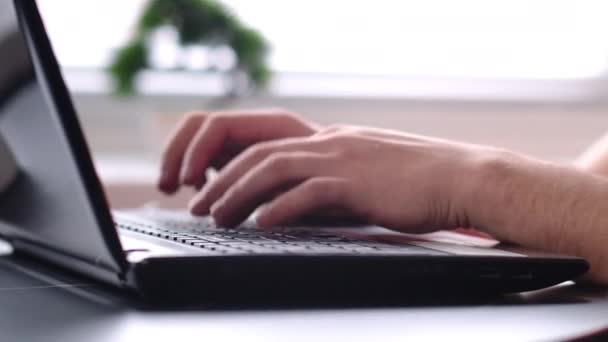 Male hands typing on laptop keyboard, typing text, camera tracking, blurred background — Stock Video