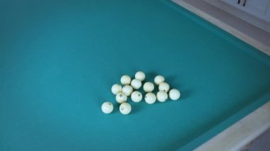 Şapkalı adam bilardo toplarını üçgen şeklinde toplar.