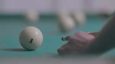 Bilardo ıstakasıyla topa vuran bir adamın elini yaklaştır.