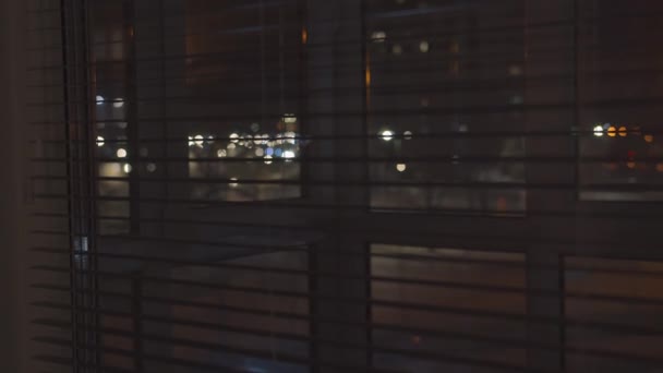 Night street, view from the window through the blinds, camera tracking — Stock Video