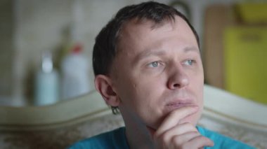 Genç bir adamın üzgün bakışları, yakın çekim.