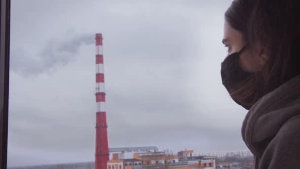 Adolescente olha para o fumo da chaminé através do vidro — Vídeo de Stock