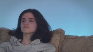 Geceleri televizyon izleyen esmer bir kızın portresi.