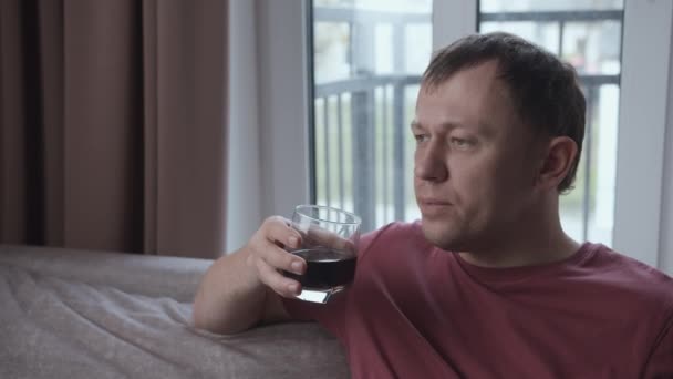 Man koppla av hemma, sitta på soffan och dricka ur ett glas, avslappning koncept — Stockvideo