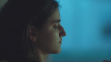 Patates cipsi yiyen ve geceleri film izleyen bir kızın yan görüntüsü.