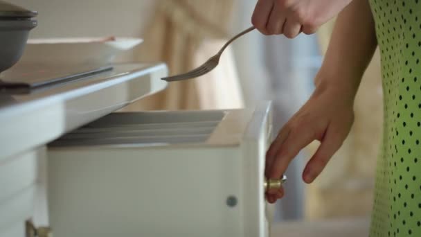 Una ragazza in un vestito prende una forchetta e un piatto di cibo e si siede a tavola per mangiare, concentrarsi rack — Video Stock