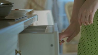 Kız bir çatal ve bir tabak yemek alıp yemek masasına oturur.