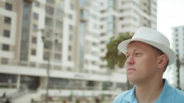 Şehir sokağında şapkalı bir gencin portresi.