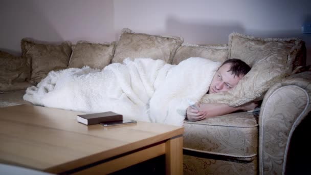 Homem solitário se deita no sofá e assiste TV — Vídeo de Stock