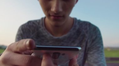 Akşam dışarıda oturan adam cep telefonunu kullanıyor, yakın plan, seçici odaklanma.