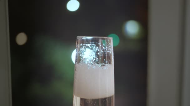 Champagne skum lägger sig i glaset, nattljus — Stockvideo