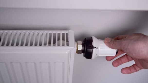 L'uomo controlla l'alimentazione di calore nel radiatore, risparmiando calore — Video Stock