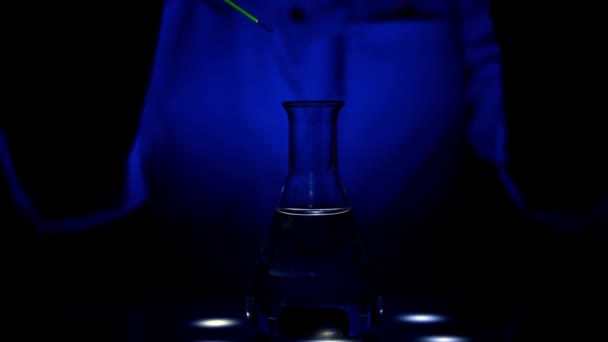 科学者は 磁気攪拌機のUv光に異なる色溶液を混合している薬化学のための化学研究所で混合の圧延運動と — ストック動画