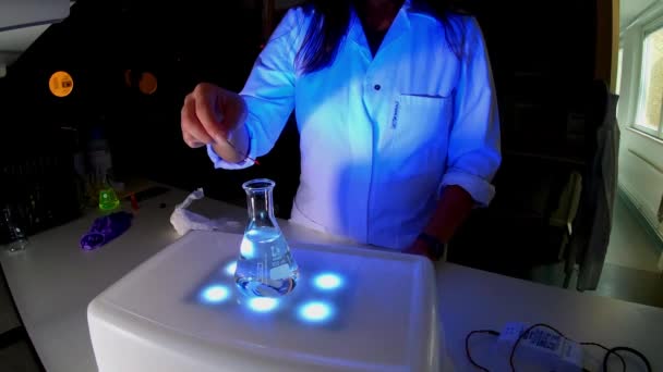 一位女科学家正在一家有荧光化合物的实验室里工作 以研制一种抗癌药物 — 图库视频影像