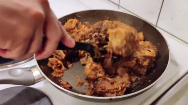 Koyun eti siyah bir tavada kızartılıyor. Sıcak bir şekilde. Bayram yemeği için karıştırılıyor ve geleneksel Hint yemeği olarak öğle yemeği.