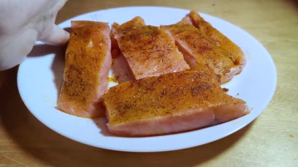 这只红色的无骨鱼在用油煮锅之前 正被婴儿的手放在白盘上 用姜黄 盐和胡椒浸泡着 — 图库视频影像