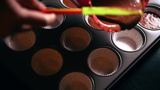 Menschliche Hand Steuerung Schokoladenkuchenteig Gießt Eine Mehrere Metall Cupcake Pfanne — Stockvideo