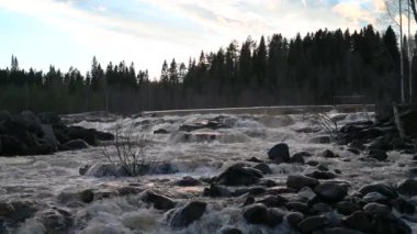 İsveç dağlarındaki su barajı ve rezervuar gölü 4k görüntüsü günbatımı dramatik bulut hareketi sırasında hidroelektrik enerjisi yenilenebilir enerji ve sürdürülebilir kalkınma üretiyor.