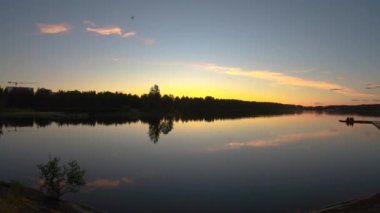 Muhteşem manzara ve sakin göl üzerinde çok renkli bir gün batımı. Gölün suyundan gelen güzel panoramik günbatımı yansıması. 4k Yavaş çekim video üzerinden it.