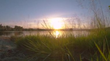 Muhteşem manzara ve sakin göl üzerinde çok renkli bir gün batımı. Gölün suyundan gelen güzel panoramik günbatımı yansıması. 4k Yavaş çekim video üzerinden it.