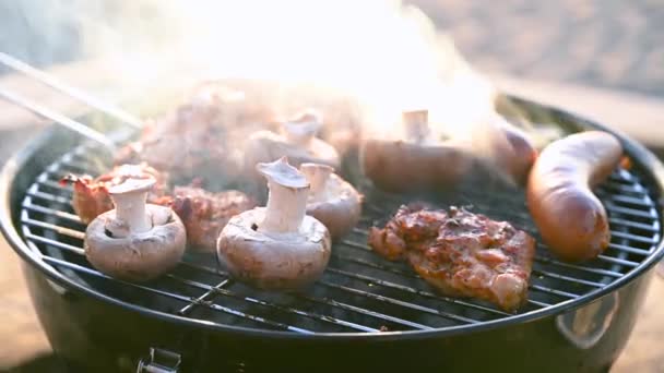 Detailní záběr grilování chutného kuřete, hub a kukuřice na grilu. Proces vaření lahodné venkovní jídlo během západu slunce. Lahodné jídlo na kovové špejli v BBQ. Video - 4K.