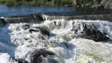 Akan suyu olan hidroelektrik baraj. Vahşi ormandaki peri şelalesi. Harika bir tatlı su şelalesi akıyor. Kükreyen bir deresi olan orman kayaları. 4K ve yavaş çekim.