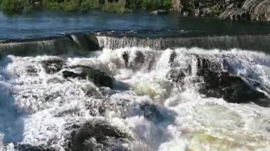 Akan suyu olan hidroelektrik baraj. Vahşi ormandaki peri şelalesi. Harika bir tatlı su şelalesi akıyor. Kükreyen bir deresi olan orman kayaları. 4K ve yavaş çekim.