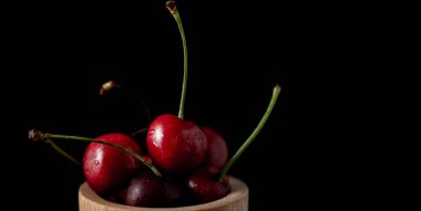 Koyu arkaplanda taze kirazlı dondurma aksiyon, sıçrama, su damlaları ve bokeh ile dinamik çekim. Yüzen taze meyve veya su damlası ve koyu arkaplan ile yükselen çekim.