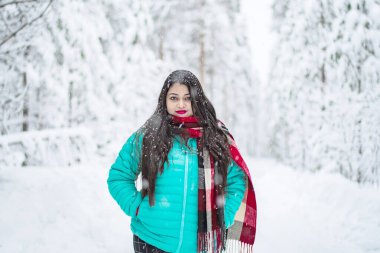  Renkli ceketli güzel bir kadının portresi. Siyah ceketli güzel bir kadın Sihirli Kış Ormanı 'nda yürüyor. Bulutlu gökyüzü ile doğal manzara. 