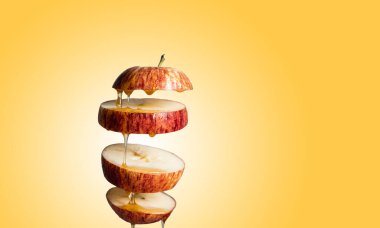 Taze dilimlenmiş kırmızı elma ve bal havada asılı duran yiyeceklere damlıyor. Alternatif şeker ikamesi, soğuk ilaç ve vücut güçlendirme, süper yiyecek kahvaltı rengi arka plan.