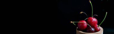 Karanlık arka planda taze kiraz koleksiyonu aksiyon, sıçrama, su damlaları ve bokeh ile dinamik çekim. Yüzen taze meyve veya su damlası ve koyu arkaplan ile yükselen çekim.