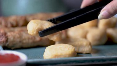 Kızarmış tavuk kanadı, tavuk nugget ve bir tabakta biftek kebabı. Kebap bir ketçap kasesine batırıldı. Masa üzerinde siyah bir arka plan 4K 'da bir Macro shot..