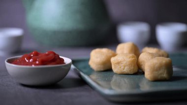 Kızarmış tavuk kanadı, tavuk nugget ve bir tabakta biftek kebabı. Kebap bir ketçap kasesine batırıldı. Masa üzerinde siyah bir arka plan 4K 'da bir Macro shot..