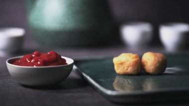 Kızarmış tavuk kanadı, tavuk nugget ve bir tabakta biftek kebabı. Kebap bir ketçap kasesine batırıldı. Masa üzerinde siyah bir arka plan 4K 'da bir Macro shot..