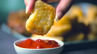 Kızarmış tavuk kanadı, tavuk nugget ve bir tabakta biftek kebabı. Kebap bir ketçap kasesine batırıldı. Masa üzerinde siyah bir arka plan 4K 'da bir Macro shot..