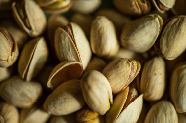 Fıstıklı fındık. Yığınla fıstık var. Yeşil arka planda izole edilmiş sağlıklı organik fındık. Kopyalama alanı