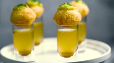 Baharatlı suyla kaplı bir bardakta Hint sokak yemeği fuşkası yakın. Pani puri Hindistan 'da bir sohbet konusu. 4K Hint sokak yemekleri.