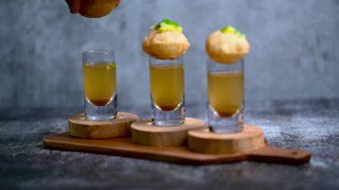 Baharatlı suyla kaplı bir bardakta Hint sokak yemeği fuşkası yakın. Pani puri Hindistan 'da bir sohbet konusu. 4K Hint sokak yemekleri.