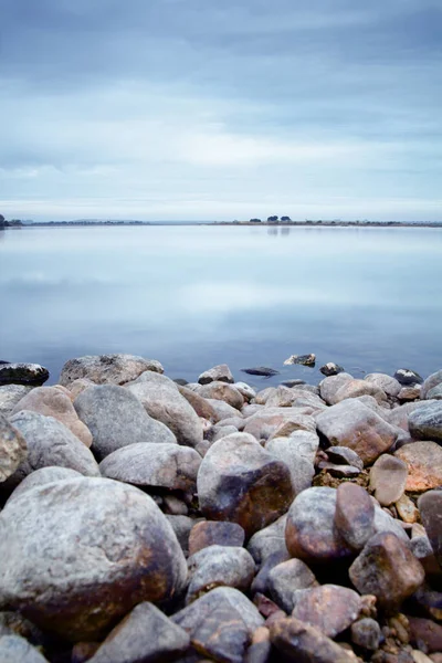 Blick Auf Einen See Mit Wolkenverhangenem Himmel Und Steinen Ufer — Stockfoto