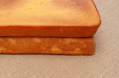 Portekiz Pao de Lo 'sunda ev yapımı Sünger Keki. Pasta hamurunun üstüne. Jüt arka planda izole edilmiş. Üst Manzara. Yatay çekim.