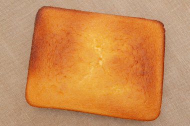 Portekiz Pao de Lo 'sunda ev yapımı Sünger Keki. Pasta hamurunun üstüne. Jüt arka planda izole edilmiş. Üst Manzara. Yatay çekim.