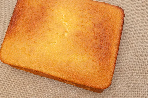 Portekiz Pao de Lo 'sunda ev yapımı Sünger Keki. Pasta hamurunun üstüne. Jüt arka planda izole edilmiş. Üst Manzara. Yatay çekim.