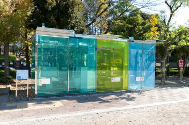 Shibuya Şehri, Tokyo, Japonya - 23 Kasım 2020: Haru-No-Ogawa Halk Parkı 'ndaki güzel şeffaf umumi tuvalet. Çapraz Görünüm. Yatay çekim.