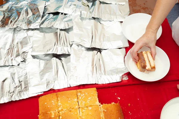 Brezilya Portekizcesinde BOLO GELADO adı verilen geleneksel Brezilya pastası. Adım adım: Kadınlar pastayı süte bandırıyor. Üst görünüm.
