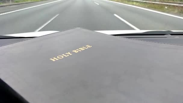 Santa Biblia Dentro Del Coche Corriendo Autopista — Vídeo de stock